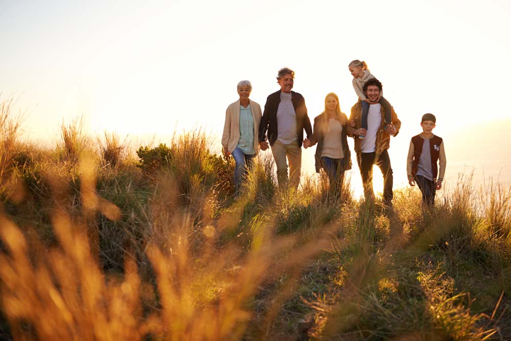 A multigenerational family walking together in golden evening light